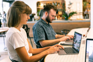 Person typing on a laptop with SEO analytics, keyword research tools, and content strategy notes on the screen, representing SEO-friendly blog writing.