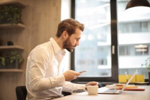 A digital marketer analyzing mobile SEO metrics on a smartphone and laptop, emphasizing the importance of mobile optimization for search rankings.